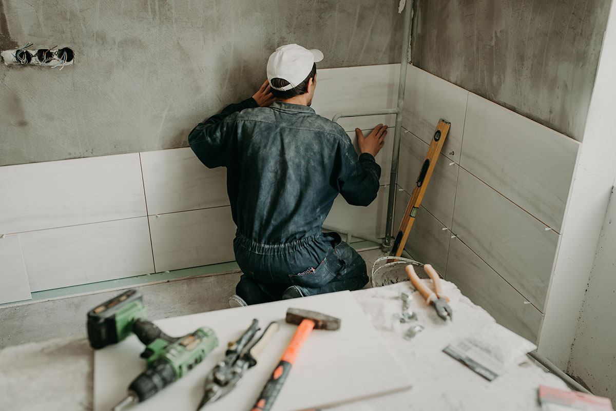 guy installing tile in bathroom